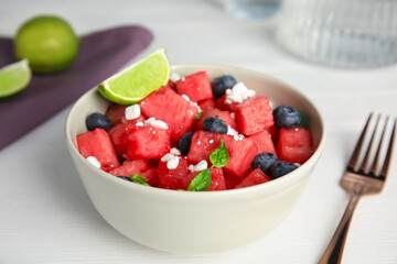 Delicious salad with watermelon, blueberries and cheese on white table, closeup