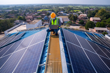 Asian technician checks the maintenance of the solar panels on the roof. - obrazy, fototapety, plakaty