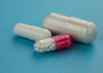 Close up of medical capsules on blue background.