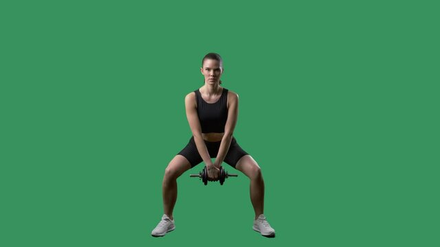 Fit young woman doing squat pulse exercise with dumbbell. Full body on chroma key green screen. 