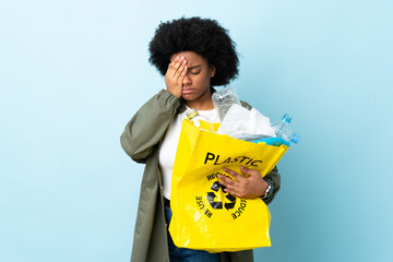 Young African American woman holding a recycle bag isolated on colorful background covering eyes by hands