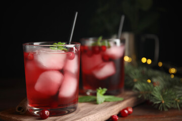 Tasty refreshing cranberry cocktail with mint on wooden table. Space for text
