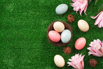 Colorful Easter eggs in the nest on a lawn with pink Double Lily flower.