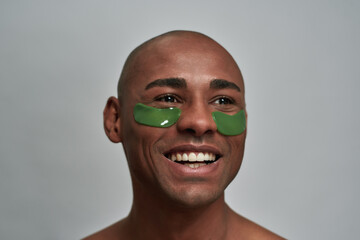 Hopeful young man with cosmetic patches staring away joyfully