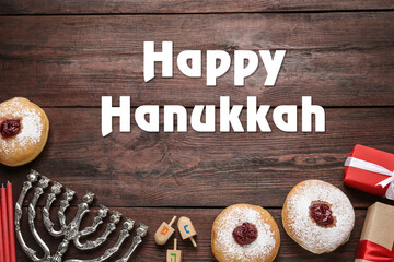 Happy Hanukkah. Traditional menorah, candles, sufganiyot and dreidels on wooden background, flat lay
