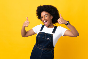 Young African American woman isolated on yellow background giving a thumbs up gesture
