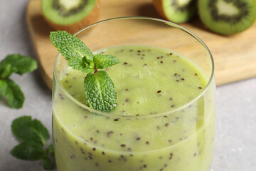 Delicious kiwi smoothie on light grey table, closeup