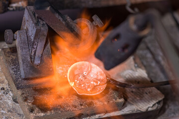 Melting process of precious metal gold behind a jeweler's workbench