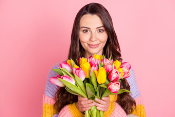 Portrait of attractive cheerful girl holding bunch tulips event occasion spring greetings isolated over pink pastel color background