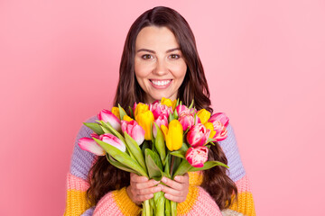 Fototapeta premium Portrait of attractive cheerful girl holding bunch tulips festal event greetings congrats isolated over pink pastel color background