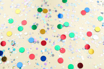 Shiny glitter on beige background, above view