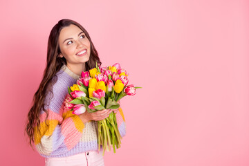 Obraz na płótnie Canvas Portrait of attractive cheerful dreamy girl holding in hands bunch tulips event copy empty space ad isolated over pink pastel color background