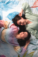 Two cute young women laying on a bed
