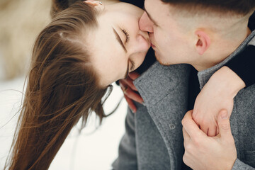 Lifestyle shot of couple walking in snowy forest. People spending winter vacation outdoors.