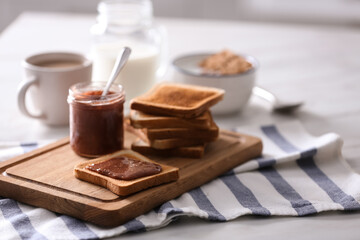 Delicious breakfast with toasts and jam on table in kitchen