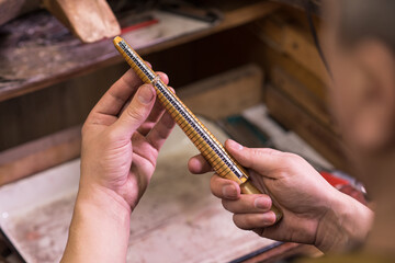 Male hands of a jeweler who measures the size of a ring using a ring gauge