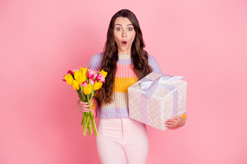 Obraz na płótnie Canvas Portrait of attractive impressed amazed girl holding in hands tulips giftbox sale offer isolated over pink pastel color background