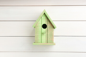 Obraz na płótnie Canvas Beautiful green bird house on white wooden background
