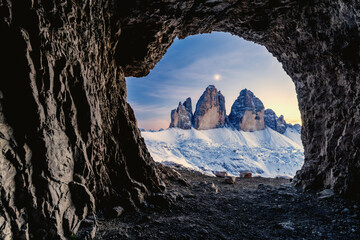 Tre Cime di Lavaredo lit by moon seen from opening in rocks of a war cave, Sesto Dolomites, Trentino-Alto Adige