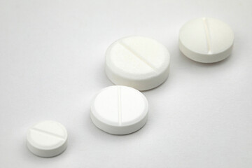 White round pills on white background. Health care concept.