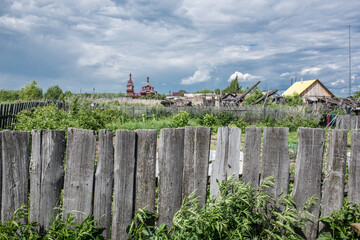 Fototapeta na wymiar Wooden Fence in Poor village of Bolshoy Balchug in Siberia