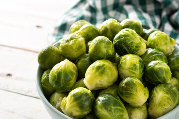 Set of brussel sprouts in a bowl on white wooden table