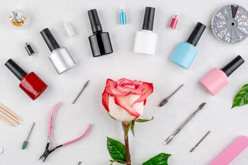 Obraz na płótnie Canvas Colorful bottles of nail polishes and tools and accessories for manicure and pedicure procedures on a white background. Top view