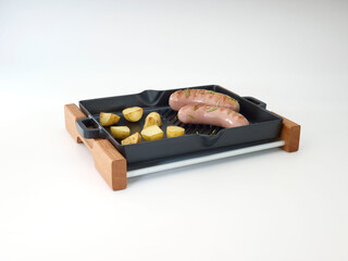 Cast iron grill and serving tray with barbeque sausage