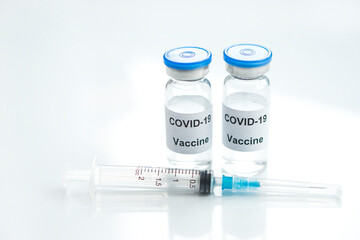 Two Vial of Covid-19 vaccine  with syringe   on white glass  medical background