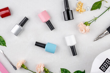 Colorful bottles of nail polishes and accessories for manicure and pedicure on a white background. Top view
