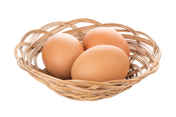 Three chicken eggs in basket on isolated white background. Clipping path.