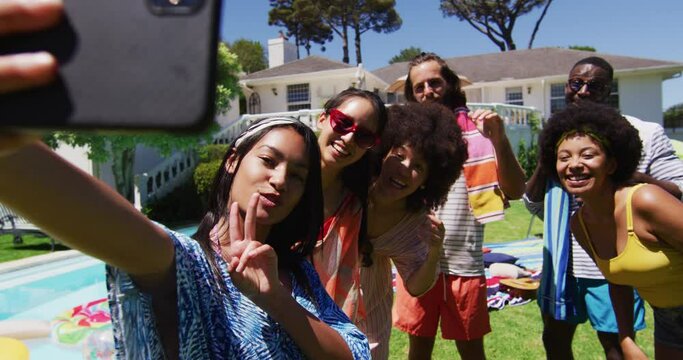 Diverse group of friends taking selfie at a pool party