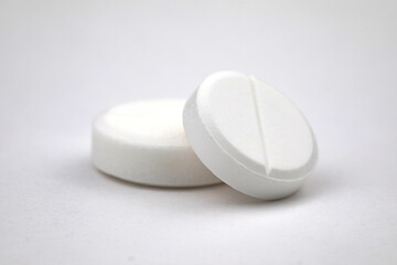 White round pills on white background. Health care concept.