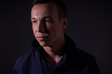 Beautiful young guy on a black background in the Studio