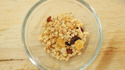 Pouring muesli breakfast mix in bowl. Close up shot