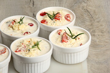 several dishes with casserole - sour cream, tomatoes and fish or other ingredients before baking. dishes with unroasted julienne 