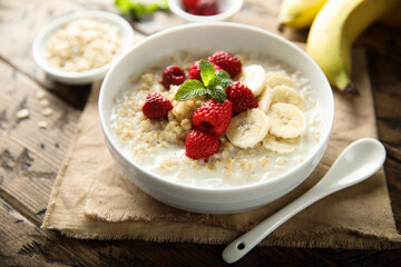 Healthy oatmeal porridge with fresh raspberry and banana - obrazy, fototapety, plakaty
