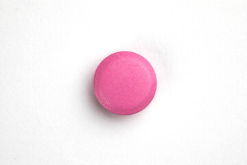 Pink round pill on white background. Health care concept.