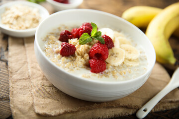 Healthy oatmeal porridge with fresh raspberry and banana