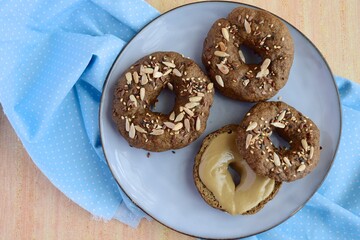 Vegan gluten free bagels topped with sunflower seeds, flax seeds and sesame seeds. Healthy breakfast food. 