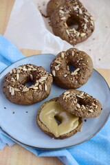 Vegan gluten free bagels topped with sunflower seeds, flax seeds and sesame seeds. Healthy breakfast food. 