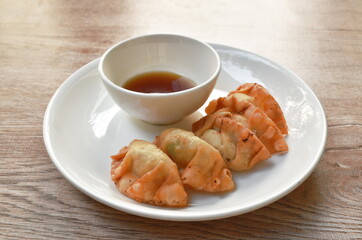 crispy fried Gyoza or Japanese dumpling stuffed mashed pork dipping shoyu sauce on plate