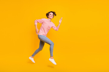 Fototapeta na wymiar Full size profile side photo of young happy positive smiling lovely girl running in air isolated on yellow color background