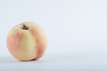 Single fresh peach on a white background