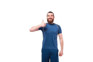 Portrait of happy smiling bearded fitness man showing thumb up over white background.
