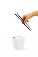 hand with chopsticks and cardboard food box on white background