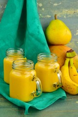 tropical yellow smoothie in a glass with mango, pear and banana