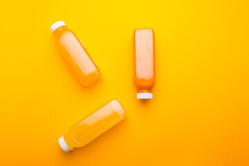 Photo of three bottles with detox juice, orange lemon carrot pineapple.