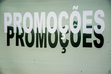 Fototapeta premium Letrero en portugués que anuncia rebajas en el escaparate de una tienda con las cortinas bajadas