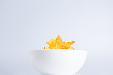 Bowl with potatoes chips isolated on white